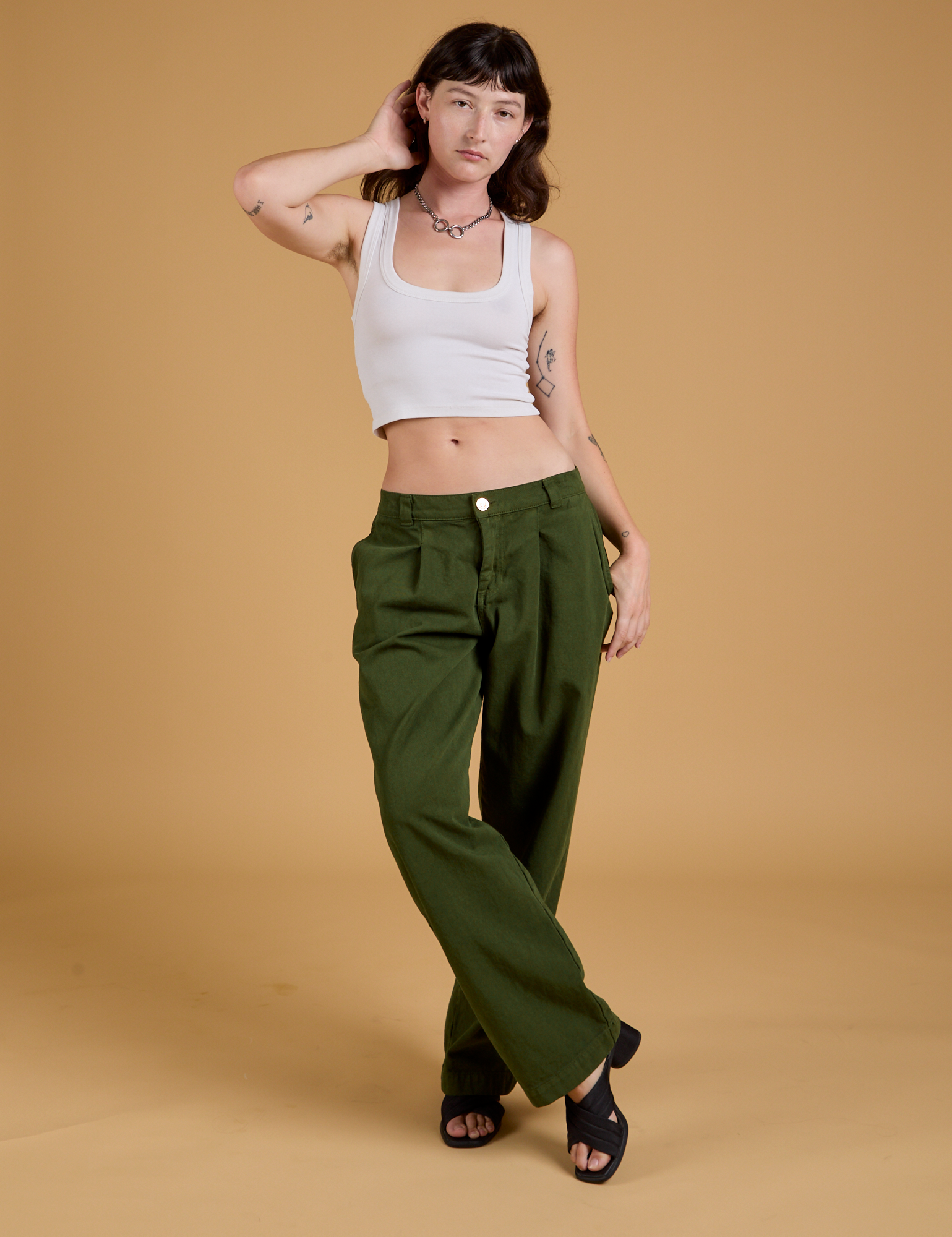 Alex is wearing Baggy Mid-Rise Trousers in Evergreen and a vintage tee white Cropped Tank