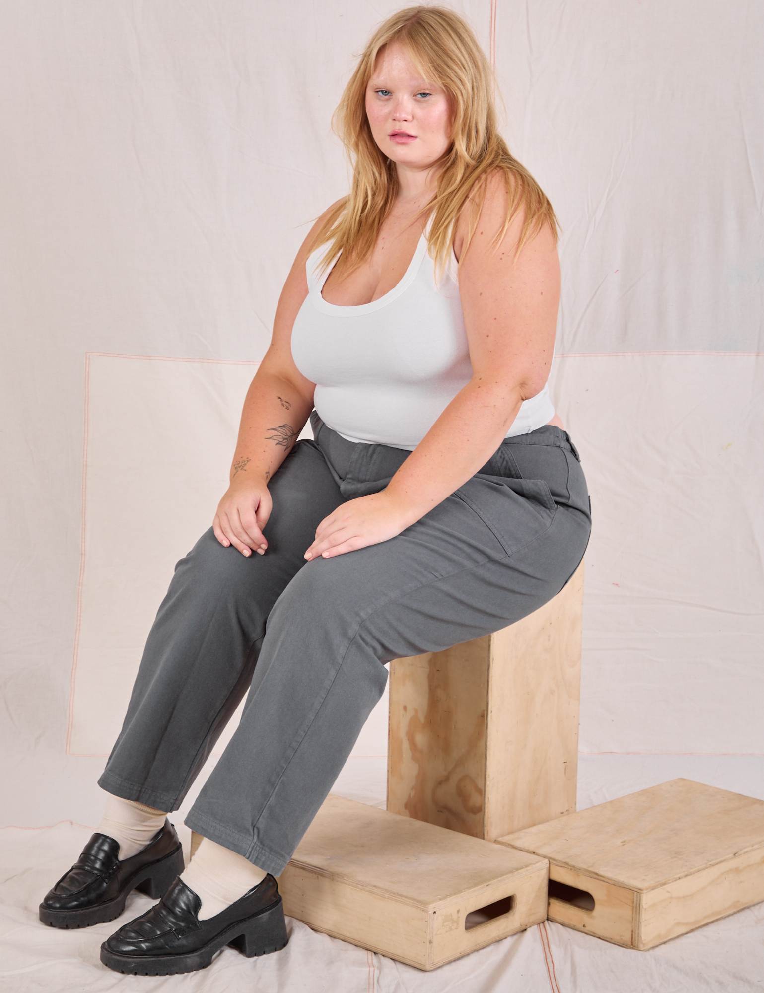 Juliet is wearing Mid-Rise Work Pants in Slate Grey and Cropped Tank in vintage tee off-white