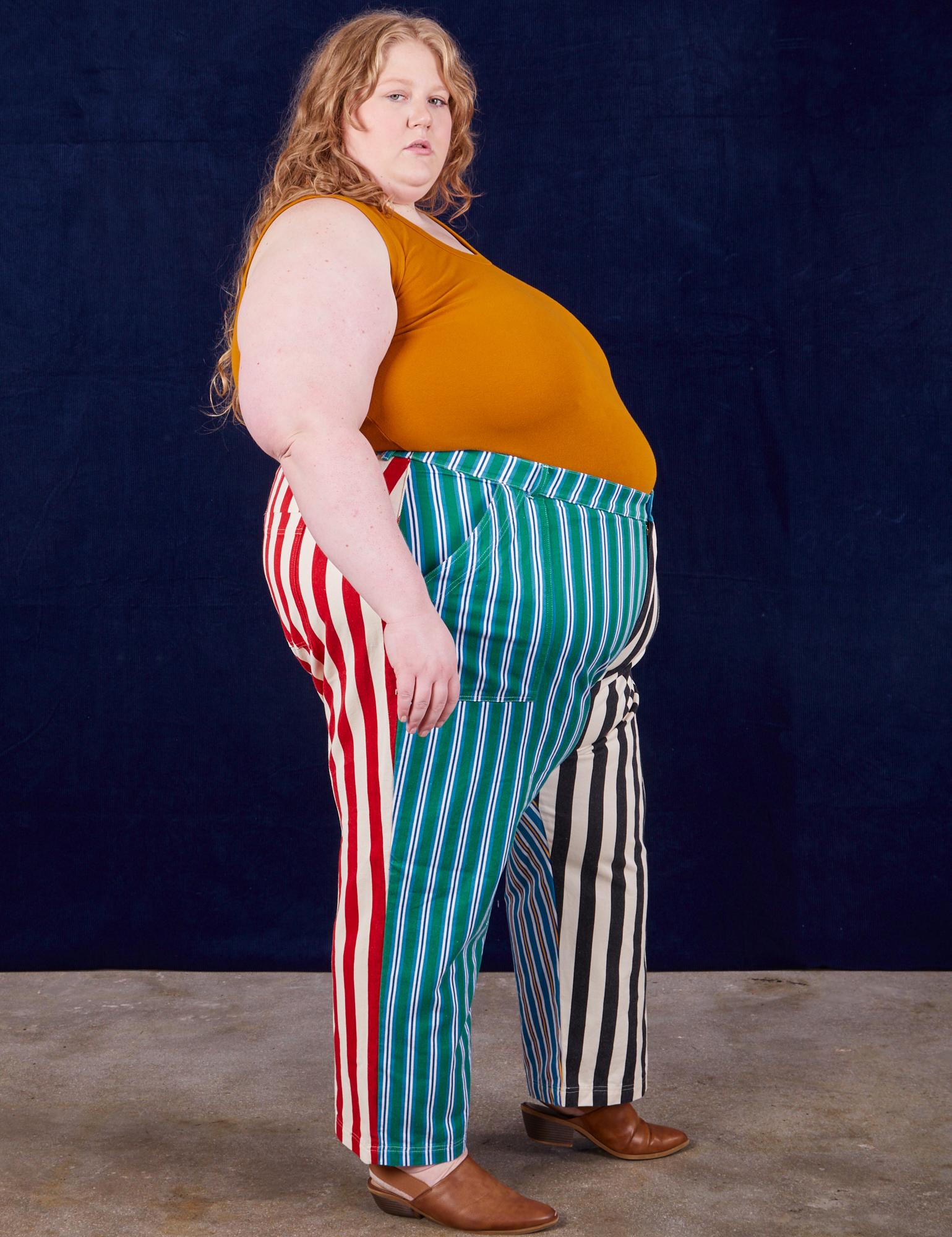 Side view of 4-Way Stripe Work Pants and spicy mustard Tank Top on Catie