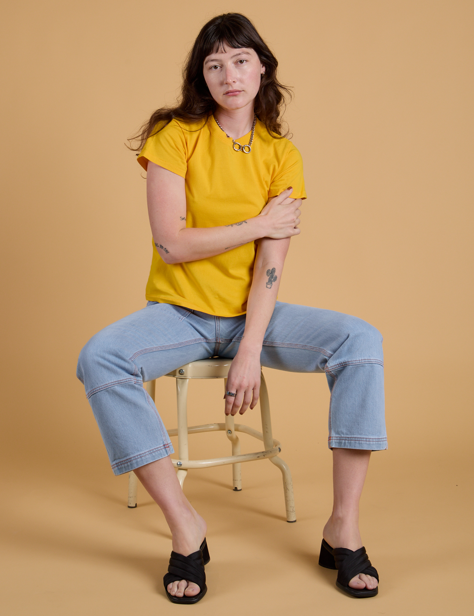 Alex is wearing Organic Vintage Tee in Sunshine Yellow and light wash Carpenter Jeans