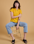 Alex is wearing Organic Vintage Tee in Sunshine Yellow and light wash Carpenter Jeans