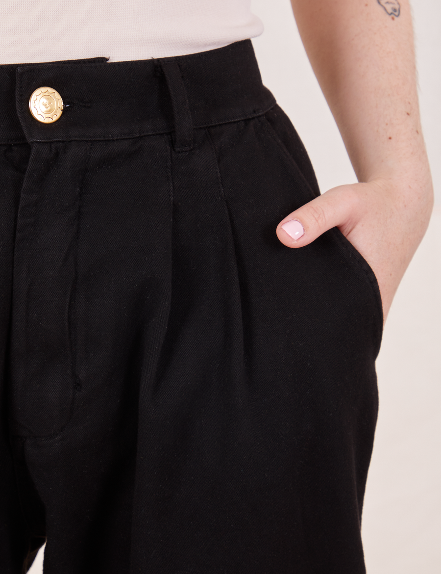 Front close up of Organic Trousers in Basic Black. Hana has her hand in the pocket.