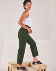 Side view of Organic Work Pants in Swamp Green and Racerback Tank in vintage tee off-white on Mika