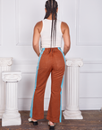 Back view of Hand-Painted Stripe Western Pants in Burnt Terracotta and vintage off-white Tank Top worn by Gabi