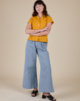 Alex is wearing Pantry Button-Up in Mustard Yellow and light wash Indigo Wide Leg Trousers