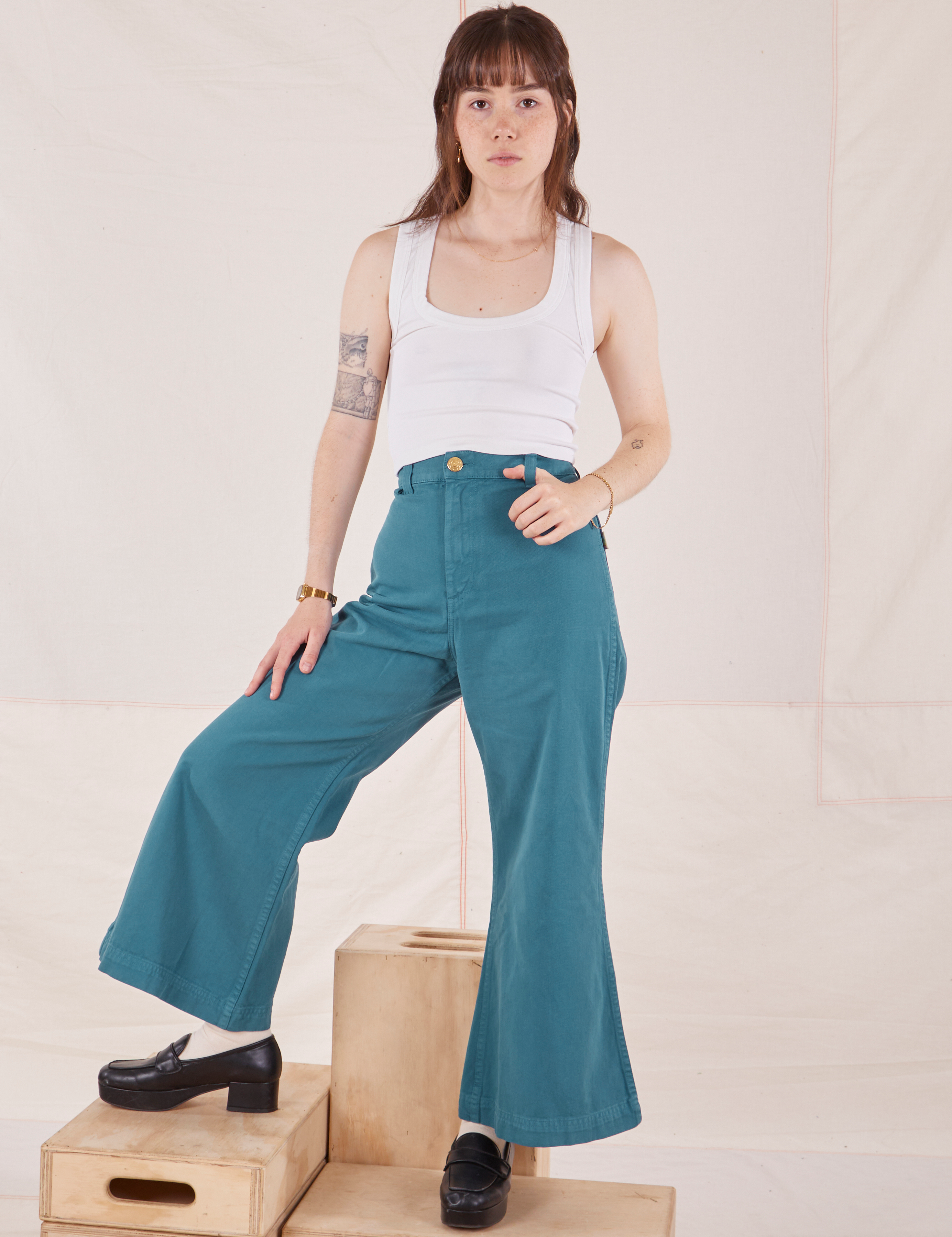 Hana is 5&#39;3&quot; and wearing P Petite Bell Bottoms in Marine Blue paired with vintage off-white Cropped Tank Top