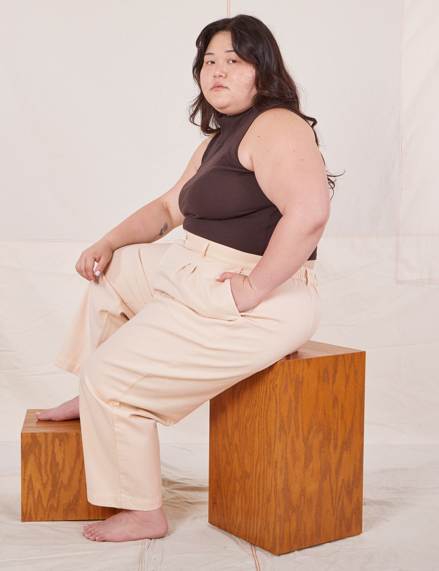 Ashley is wearing Heritage Trousers in Vintage Off-White and espresso brown Sleeveless Turtleneck