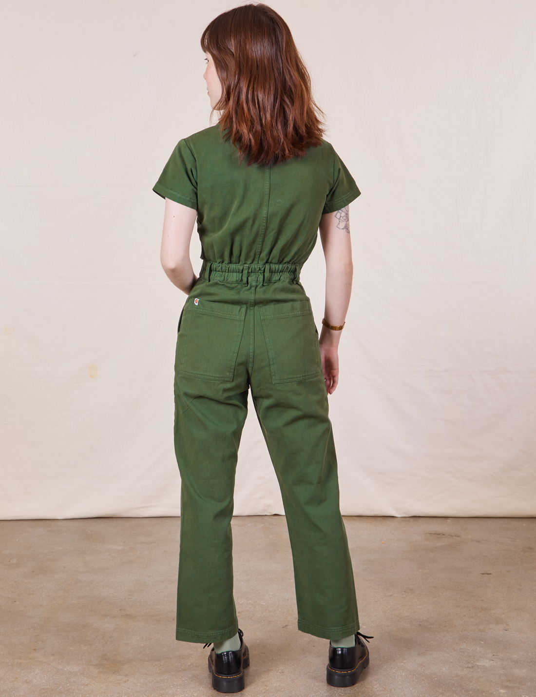 Petite Short Sleeve Jumpsuit in Dark Emerald Green back view on Hana