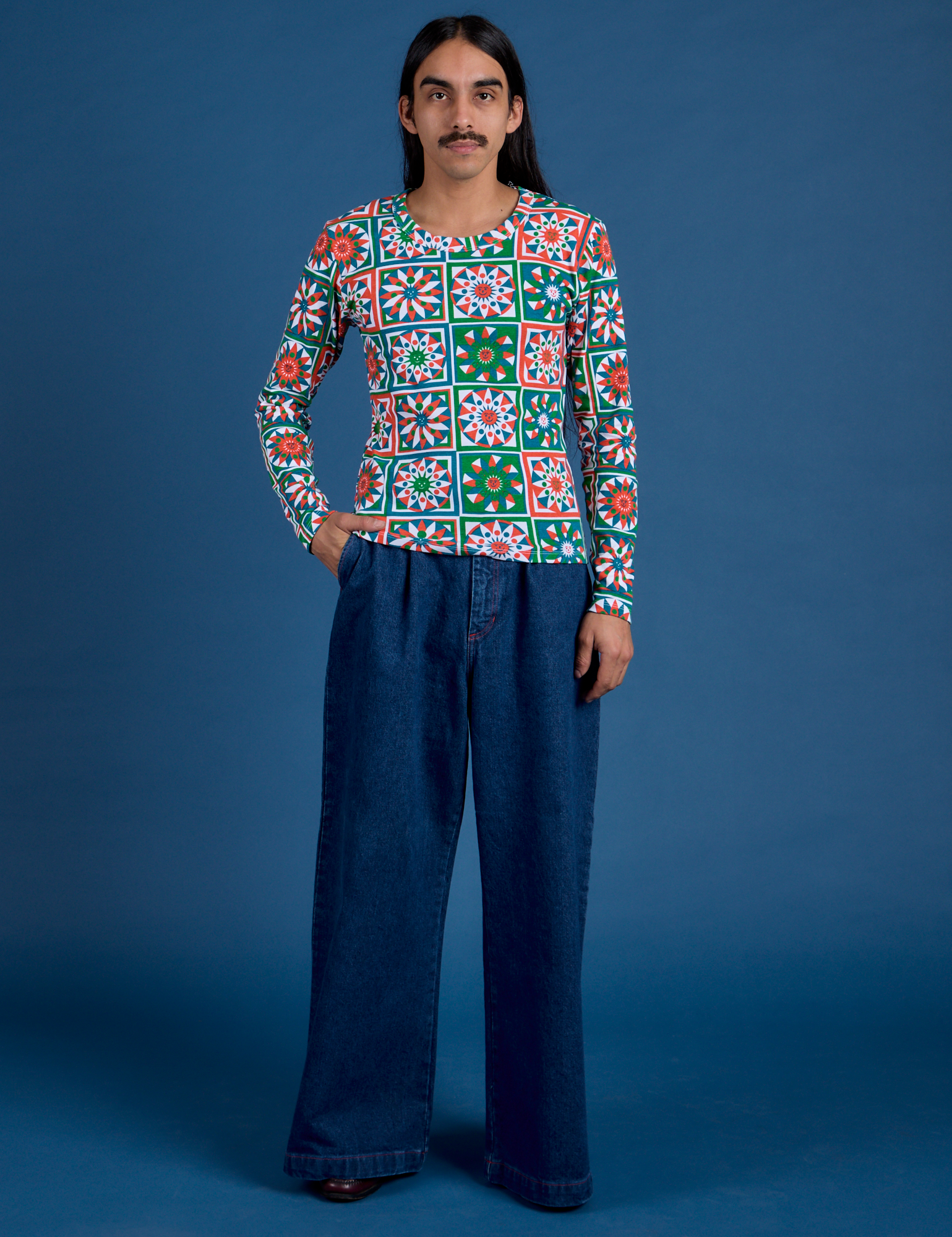 Anthony is wearing Long Sleeve Baby Tee in Quilt Print paired with dark wash Indigo Wide Leg Trousers
