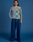 Anthony is wearing Long Sleeve Baby Tee in Quilt Print paired with dark wash Indigo Wide Leg Trousers
