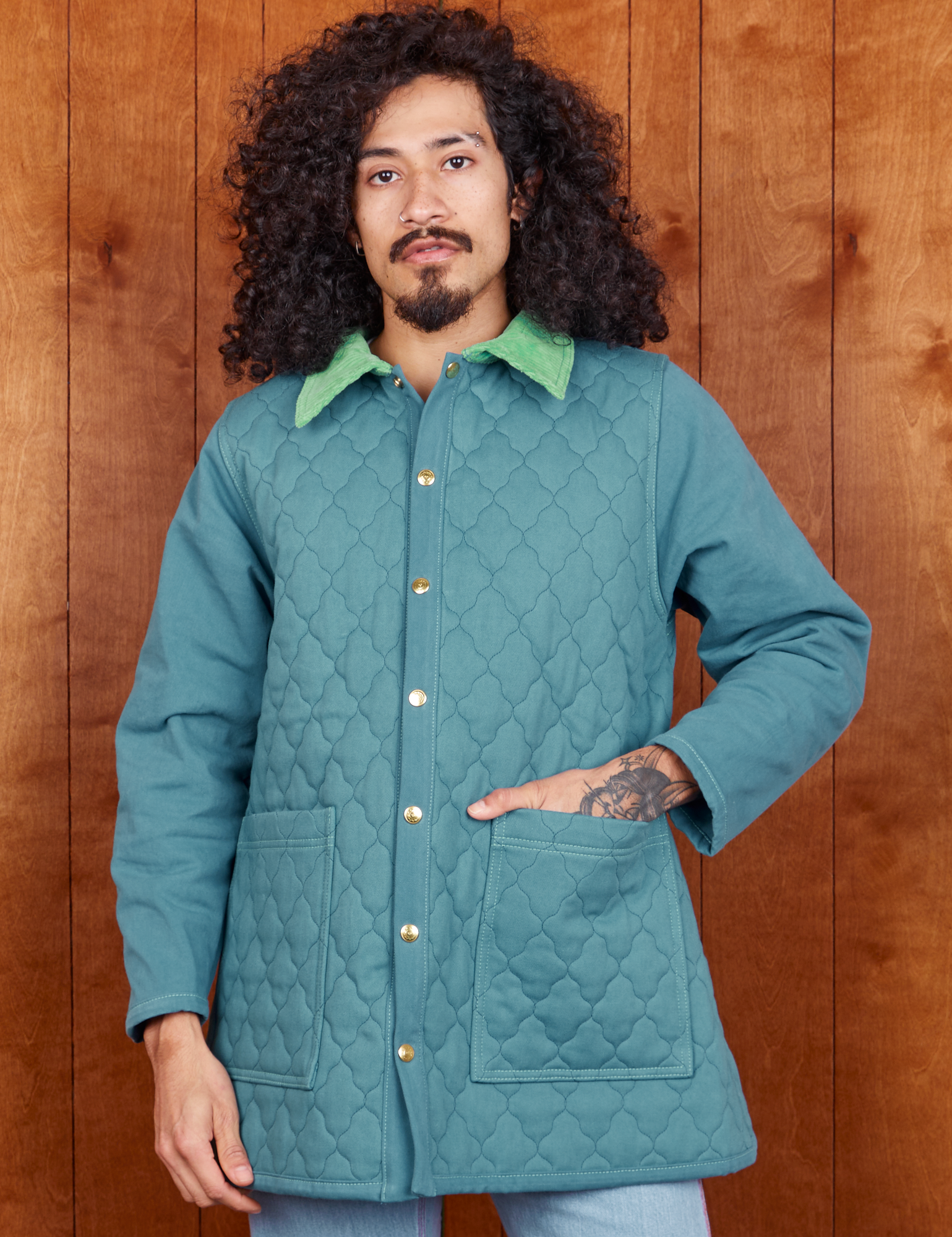 Jesse is wearing a buttoned up Quilted Overcoat in Marine Blue
