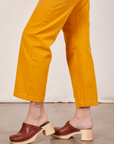 Side view pant leg close up of Short Sleeve Jumpsuit in Mustard Yellow worn by Alex