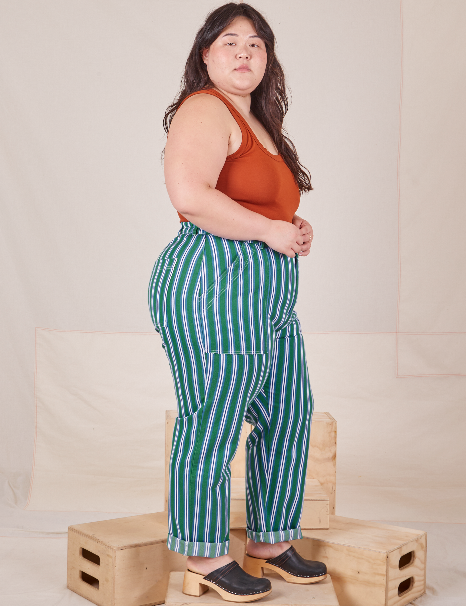 Side view of Stripe Work Pants in Green and burnt terracotta Tank Top worn by Ashley