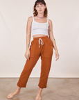Alex is wearing Cropped Rolled Cuff Sweatpants in Burnt Terracotta and vintage off-white Cami