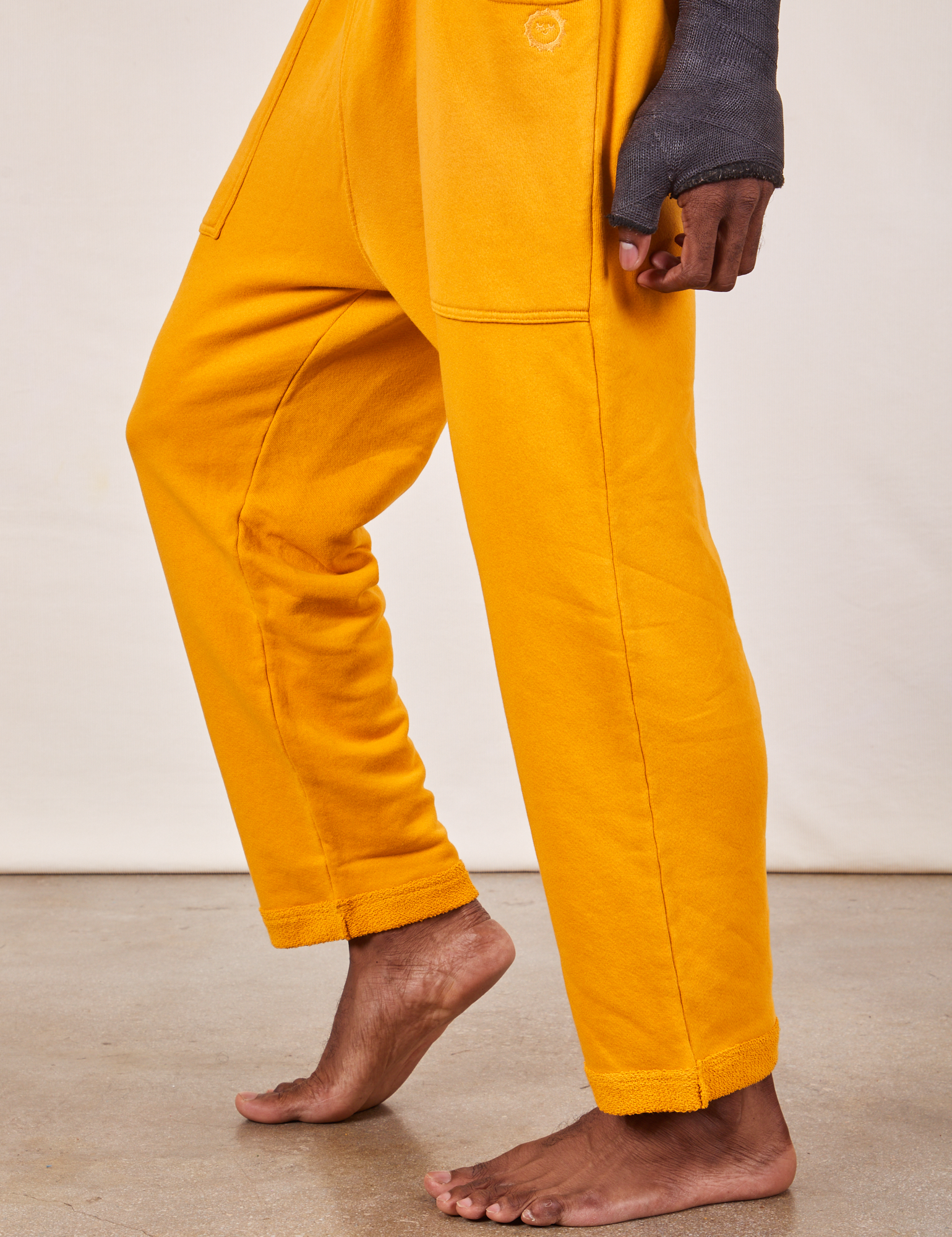 Cropped Rolled Cuff Sweatpants in Mustard Yellow pant leg side view close up on Jerrod