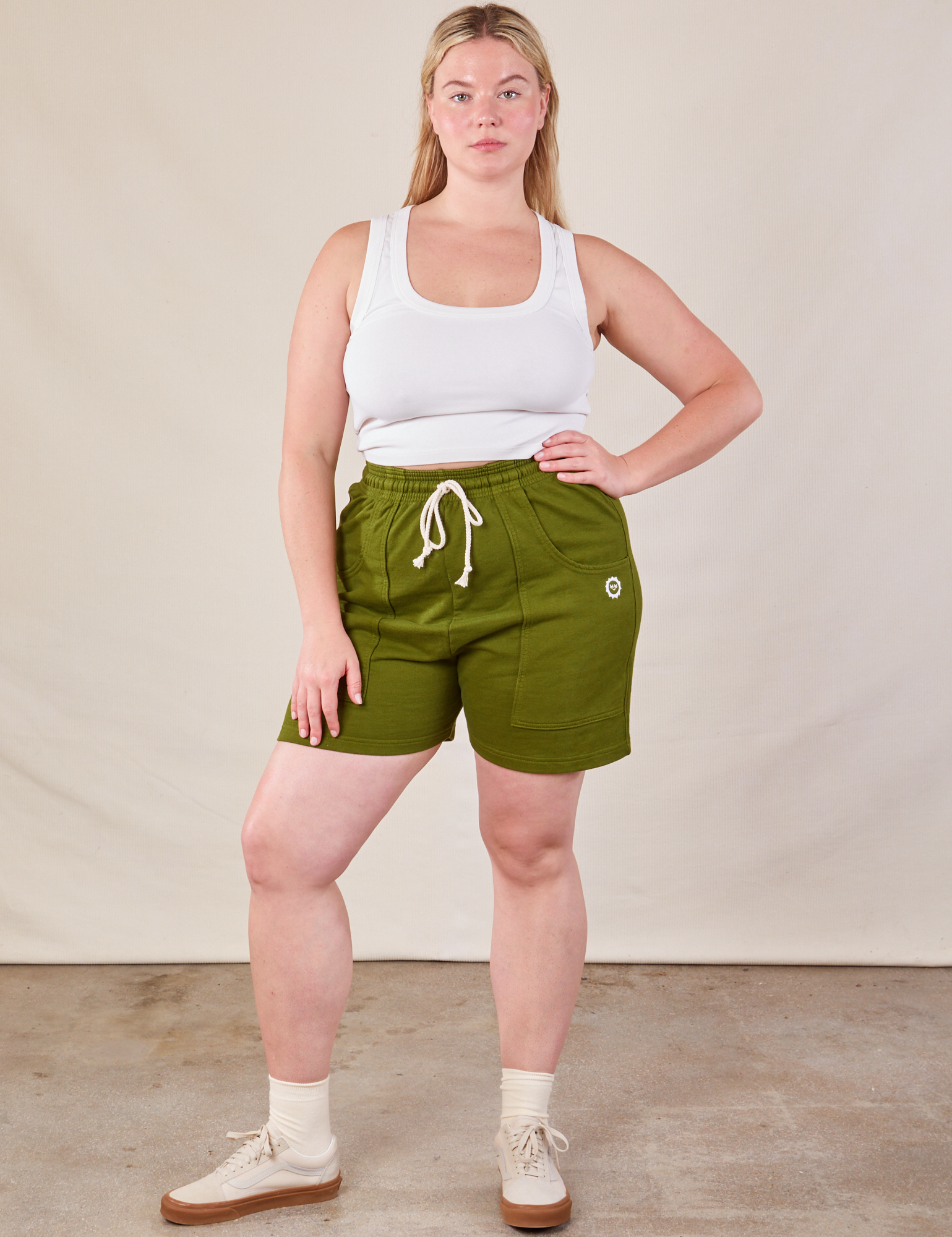 Lish is 5’8” and wearing S Lightweight Sweat Shorts in Summer Olive paired with a Cropped Tank in vintage tee off-white