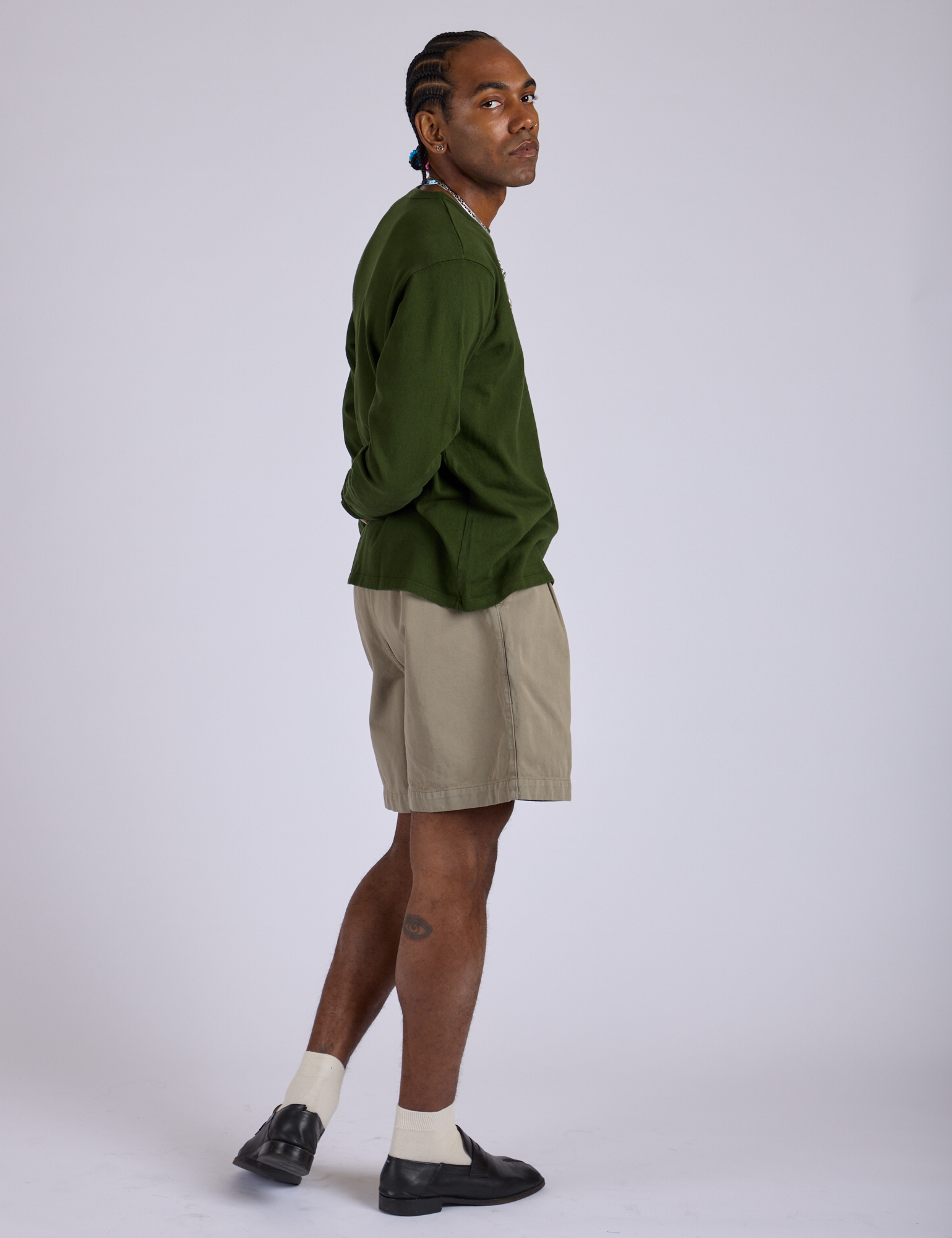 Side view of Pleated Trouser Shorts in Khaki Grey paired with evergreen Long Sleeve Burly Tee