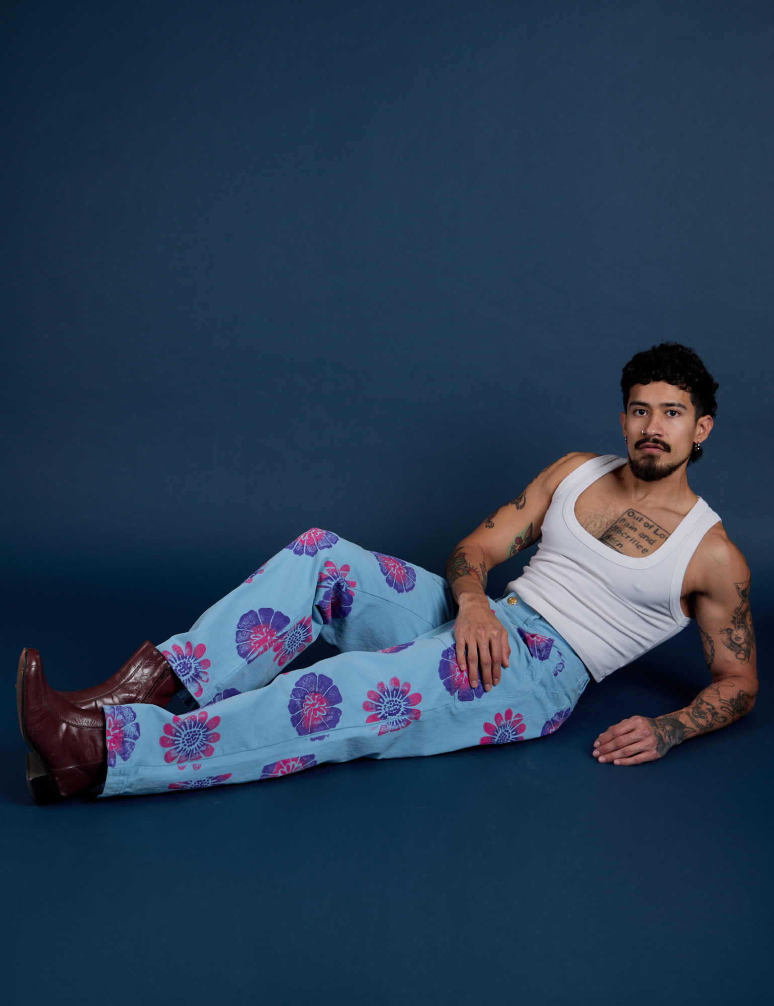 Jesse is wearing Floral Painted Work Pants in Blue and vintage tee white Cropped Tank