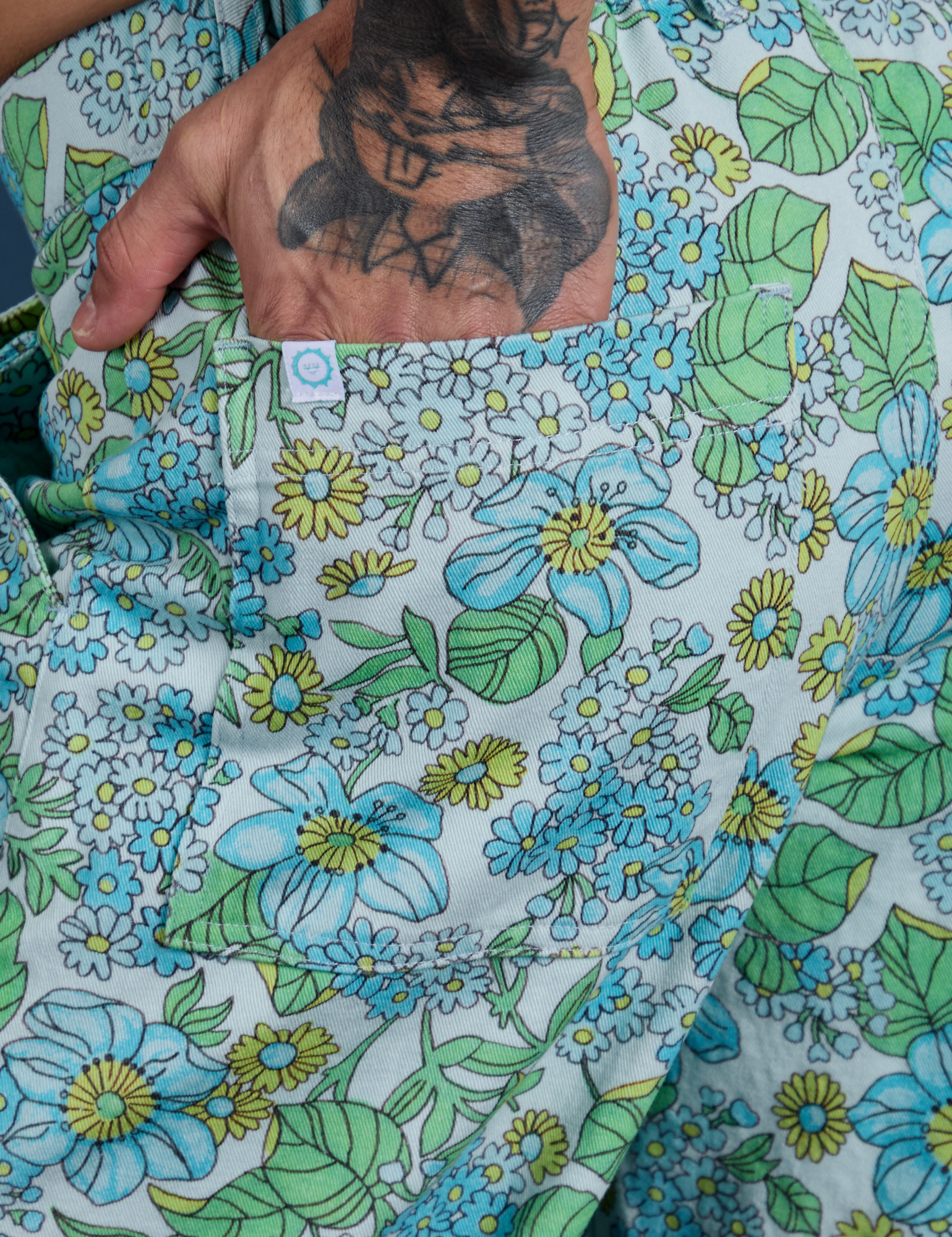 Close up of Jesse's hand in the back pocket of Winter Floral Print Work Pants