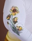 Close up of screen-print flowers on sleeve of Floral Long Sleeve Baby Tee in Yellow 