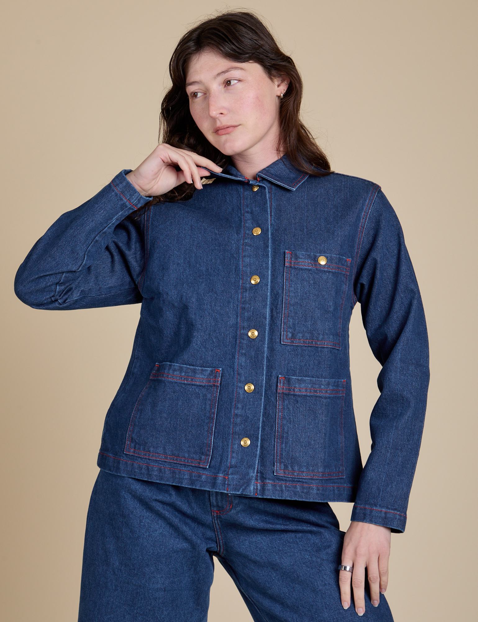 Alex is wearing a buttoned up Indigo Denim Work Jacket in Dark Wash