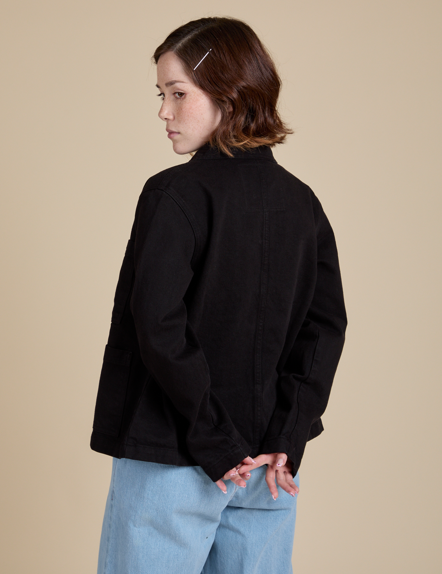 Angled back view of Work Jacket in Basic Black on Hana