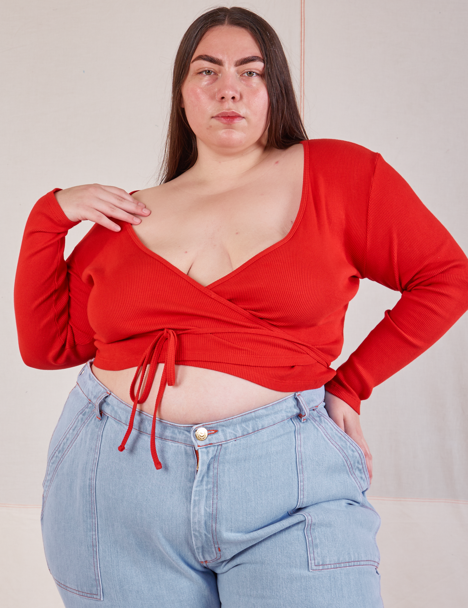 Marielena is 5’8” and wearing size 4 Wrap Top in Mustang Red