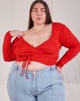 Marielena is 5’8” and wearing size 4 Wrap Top in Mustang Red