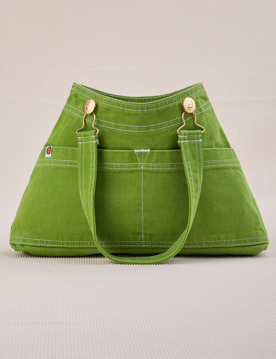 Overall Handbag in Bright Olive. Handle strap laying down front of bag