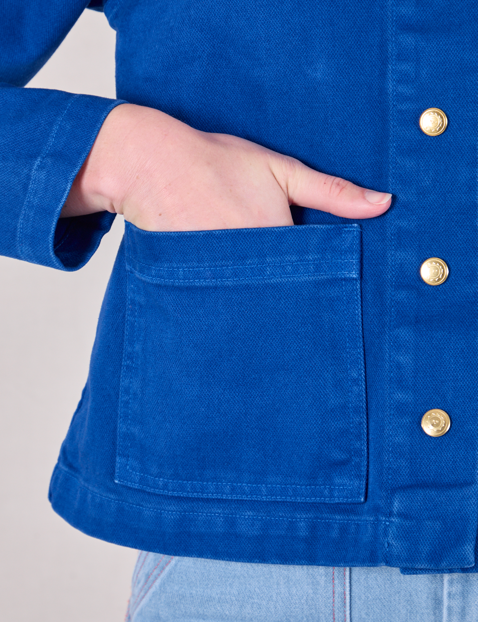 Close up of Alex&#39;s hand in the front pocket of Denim Work Jacket in Royal Blue