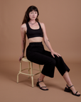 Alex is wearing Action Pants in Basic Black and Mini Tank in Black