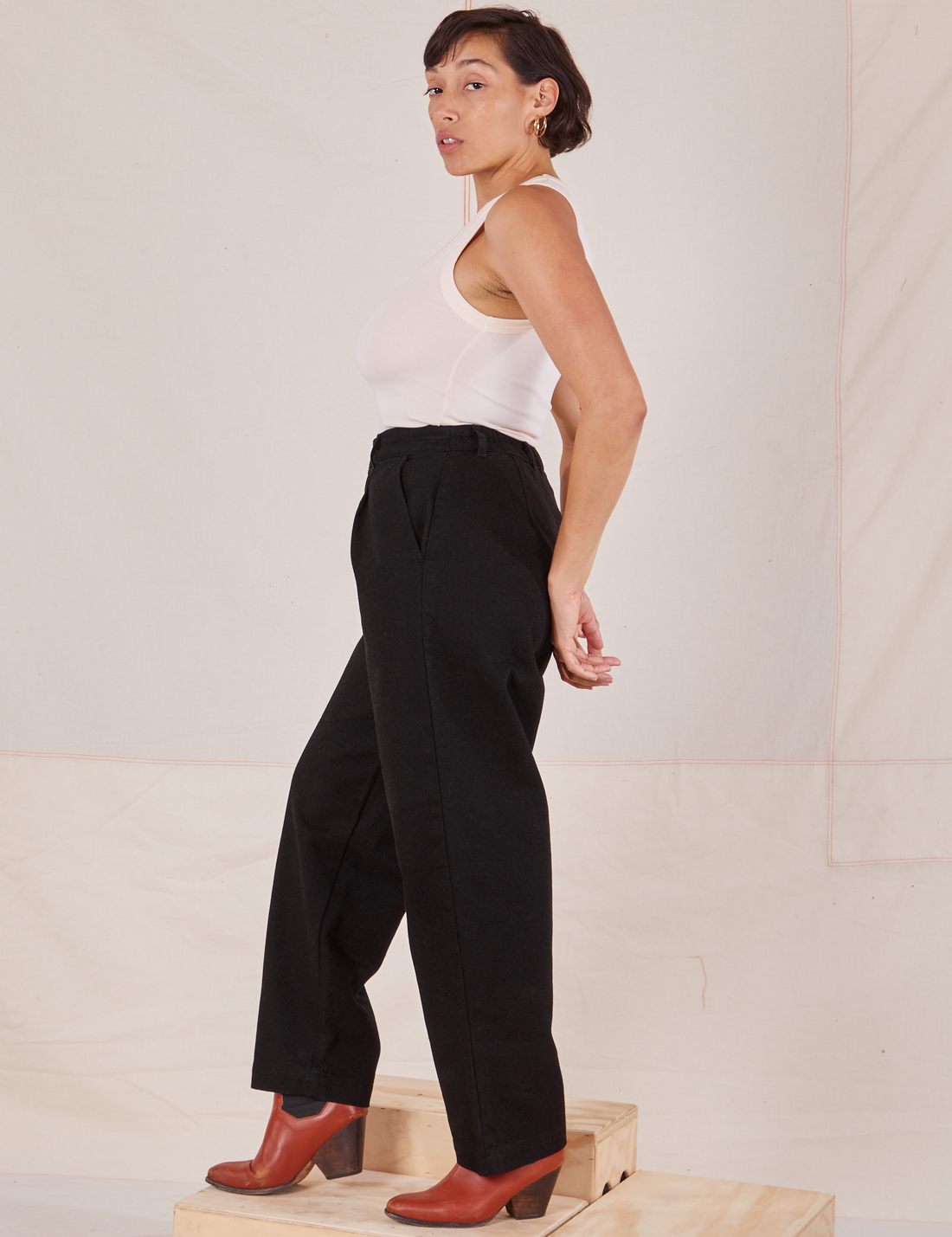 Side view of Denim Trouser Jeans in Black and vintage off-white Tank Top worn by Tiara.