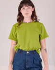 Alex is wearing Burly Tee in Gross Green tucked into her dark wash Denim Wide Leg Trousers