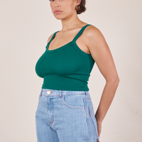 Angled view of Cropped Cami in Hunter Green and light wash Sailor Jeans worn by Tiara