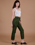 Angled front view of Carpenter Jeans in Evergreen and Cropped Tank in Vintage Tee White on Alex