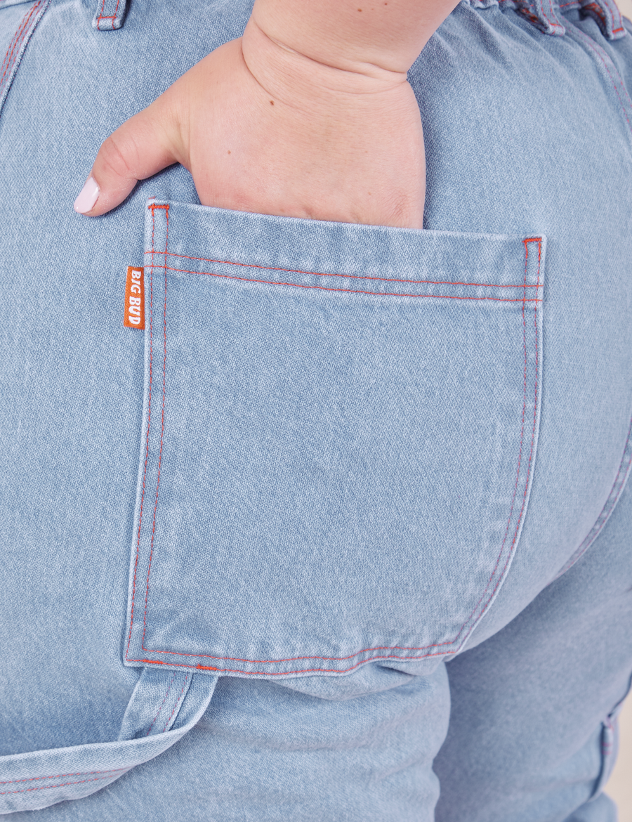 Back pocket close up of Carpenter Jeans in Light Wash. Ashley has her hand tucked into the pocket.