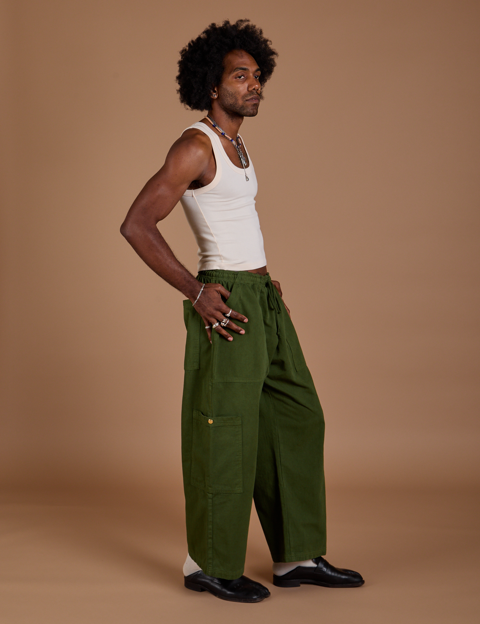 Side view of Drop Pocket Cargo Pants in Evergreen and Tank Top in vintage tee white on Jerrod
