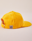 Side view of Dugout Corduroy Hat in Sunshine Yellow. Big Bud label sewn on edge of hat.