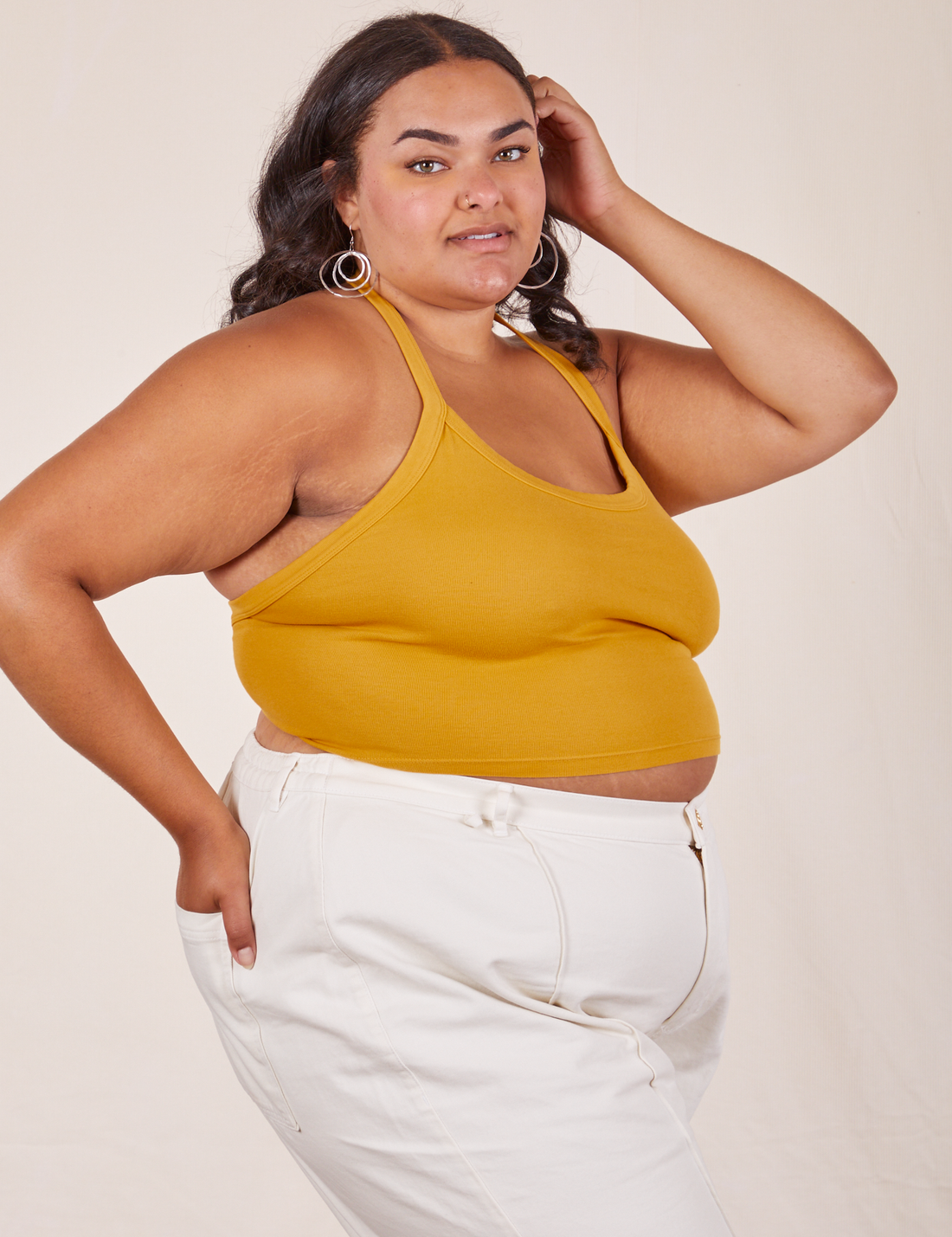 Angled view of Halter Top in Mustard Yellow and vintage off-white Western Pants worn by Alicia