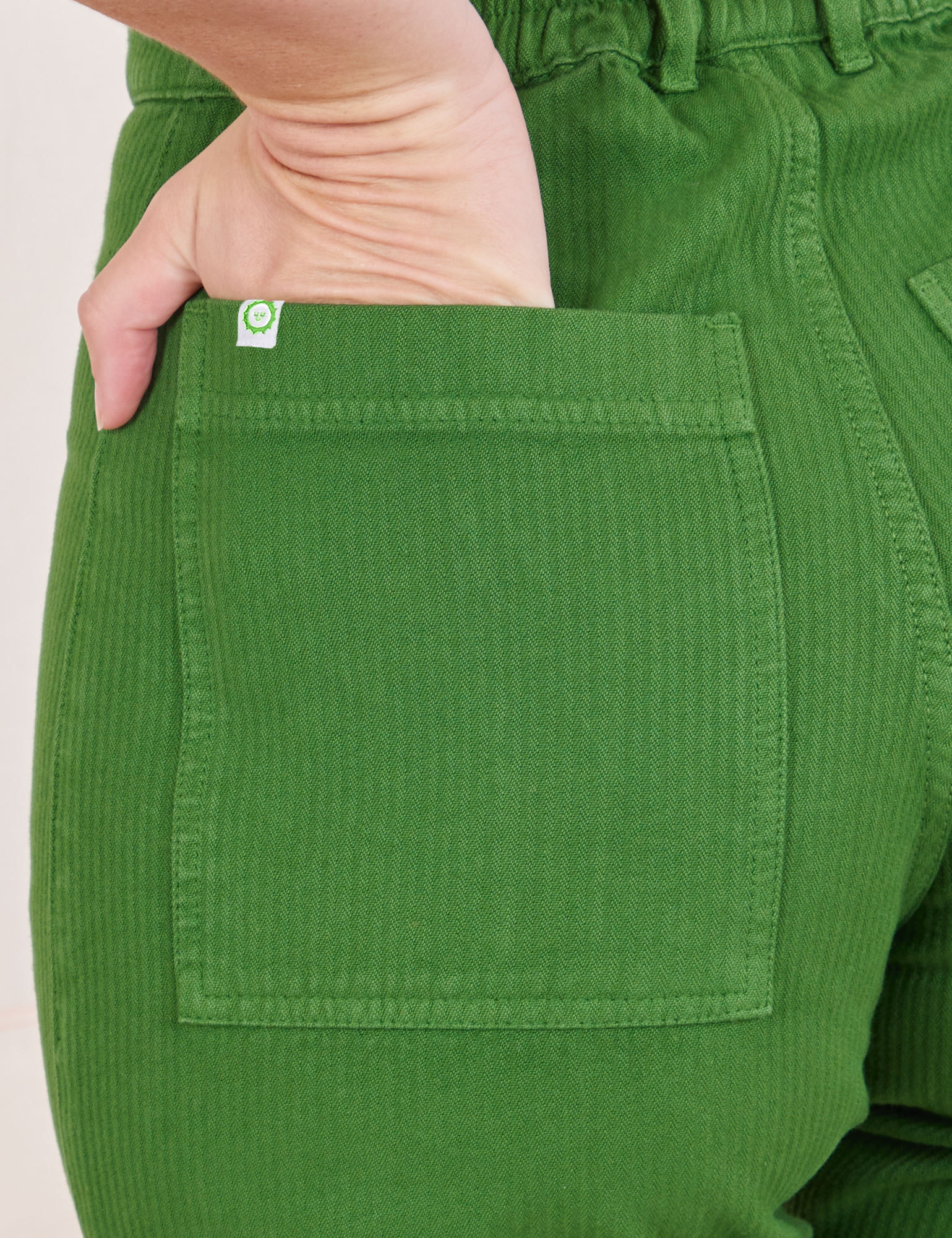 Heritage Westerns in Lawn Green back pocket close up. Alex has her hand in the pocket.