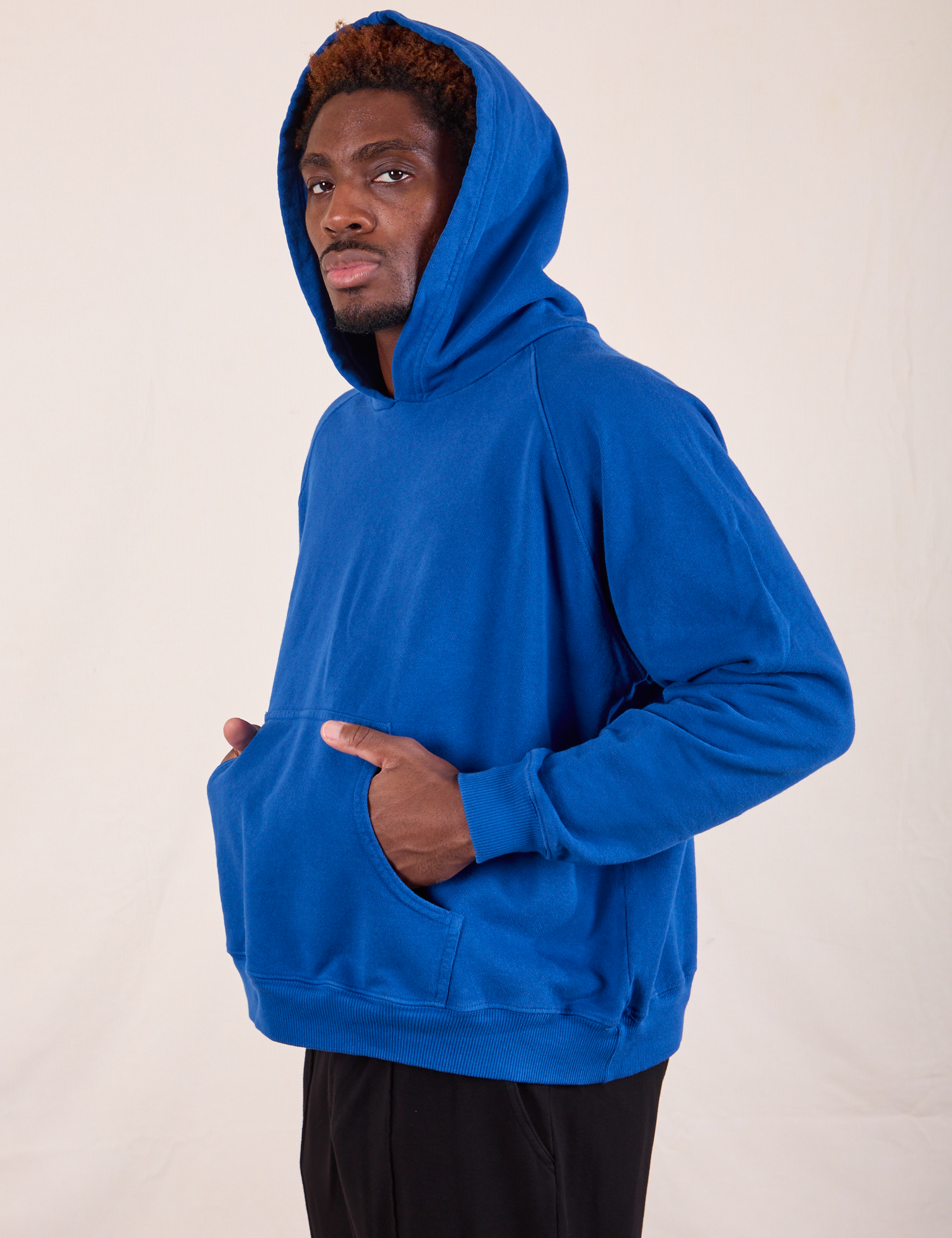 Oversized Hoodie in Royal Blue side view on Issac which hood on.