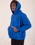 Oversized Hoodie in Royal Blue side view on Issac which hood on.