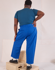 Back view of Mid-Rise Pleated Trousers in Royal Blue and lagoon Baby Tee on Elijah