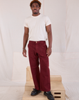 Issac is 5'10" and wearing M Mid-Rise Work Pants in Red Wine paired with Organic Vintage Tee in vintage tee off-white