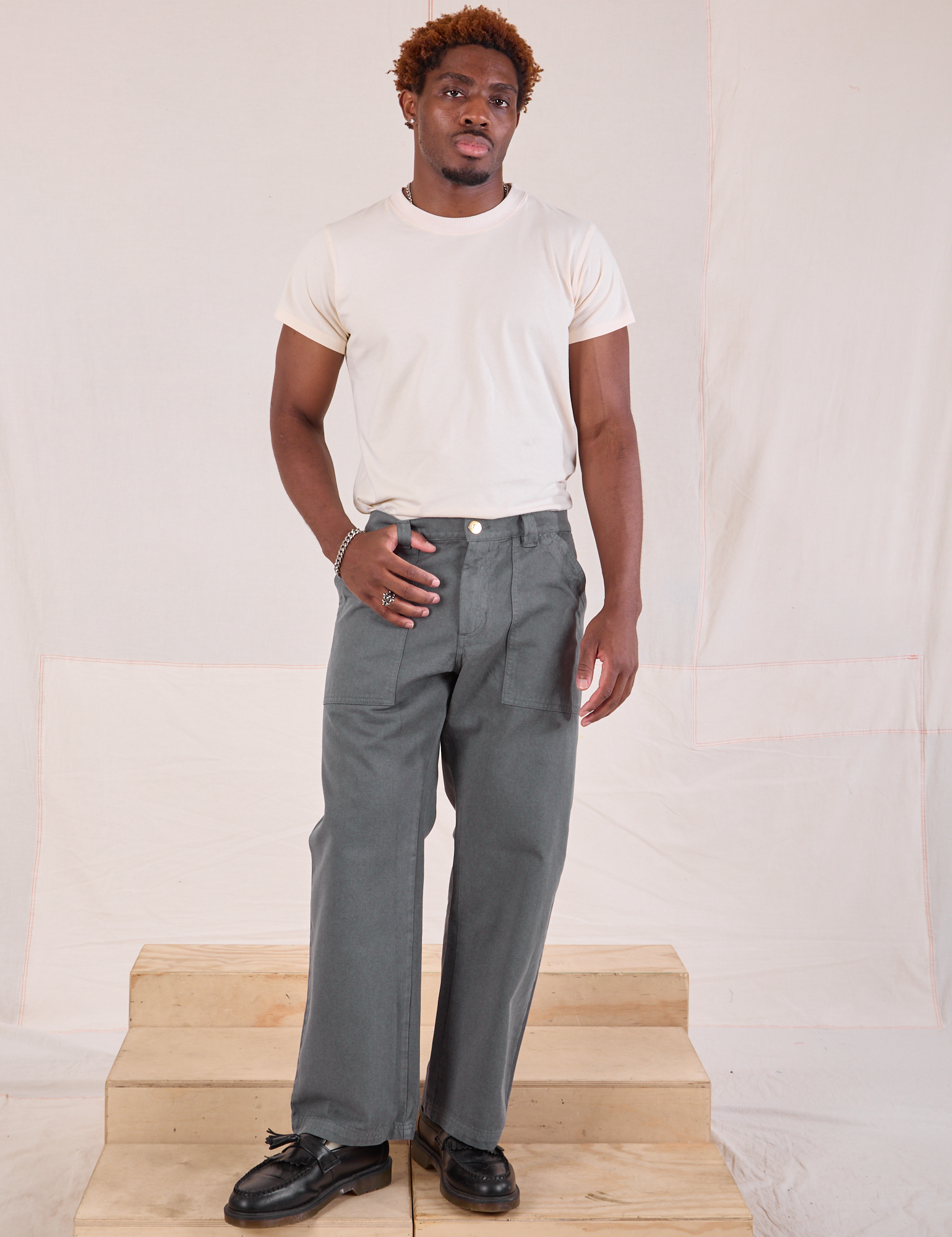 Issac is 5&#39;10&quot; and wearing M Mid-Rise Work Pants in Slate Grey paired with an Organic Vintage Tee in vintage tee off-white