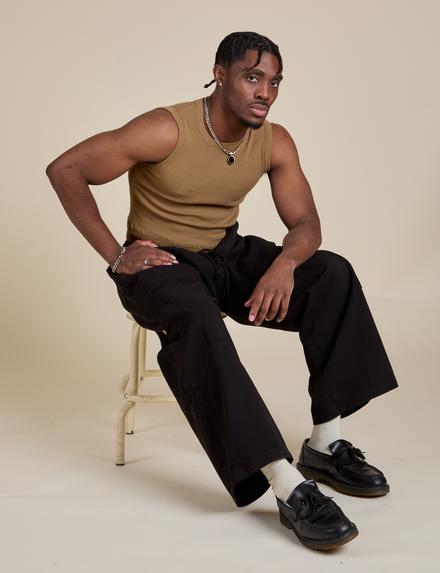 Isaac is wearing Muscle Tee in Desert Brown and black Drop Pocket Cargo Pants