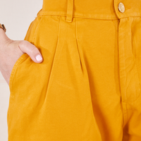 Front close up of Organic Trousers in Mustard Yellow. Hana has her hand in the pocket.
