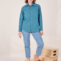 Alex is wearing a buttoned up Oversize Overshirt in Marine Blue paired with light wash Frontier Jeans
