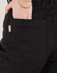 Petite Bell Bottoms in Basic Black back pocket close up. Hana has her hand in the pocket.