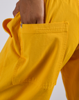 Close up of Kira's hand in the back pocket of Drop Pocket Cargo Pants in Sunshine Yellow